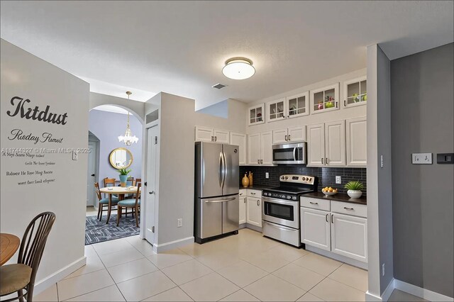 2120 SE 17th Ave, Homestead, FL 33035 - kitchen featuring stainless steel appliances, dark countertops, decorative backsplash, a chandelier, and white cabinets
