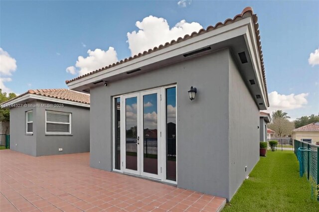 2120 SE 17th Ave, Homestead, FL 33035 - rear view of house with a tiled roof, stucco siding, a patio area, and french doors