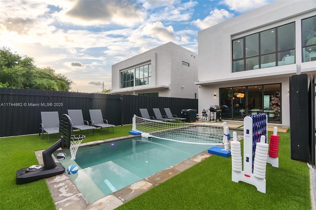 view of swimming pool with area for grilling and a lawn