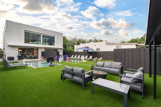 view of yard featuring a fenced in pool and an outdoor living space with a fire pit