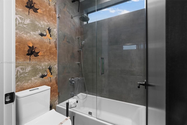 bathroom featuring enclosed tub / shower combo and toilet