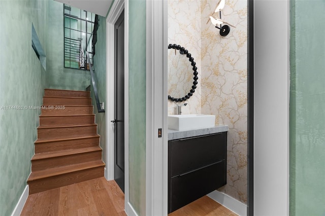 staircase featuring hardwood / wood-style floors and sink