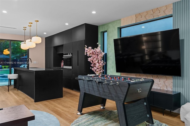 playroom featuring sink and light hardwood / wood-style floors