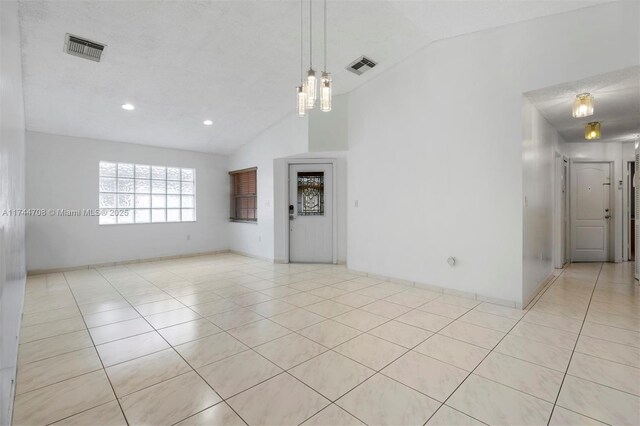 tiled empty room with lofted ceiling