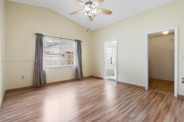 unfurnished room with lofted ceiling, a wealth of natural light, and light wood-type flooring