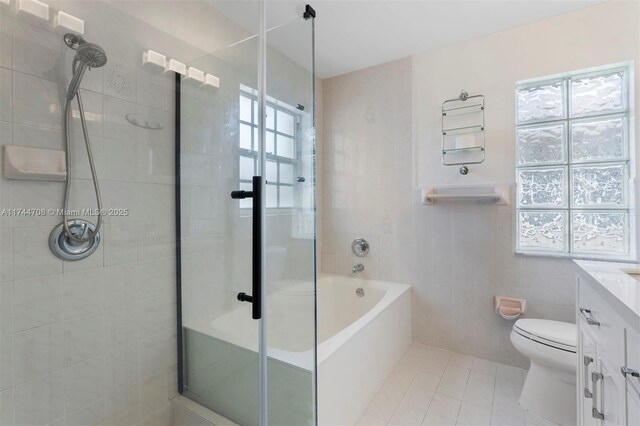 full bathroom featuring tile patterned floors, toilet, separate shower and tub, tile walls, and vanity