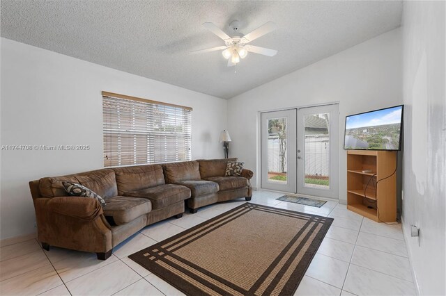 tiled living room featuring vaulted ceiling, ceiling fan, a textured ceiling, and french doors