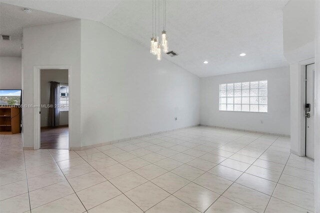 tiled spare room with high vaulted ceiling