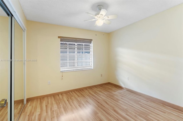 unfurnished bedroom with ceiling fan, a textured ceiling, light wood-type flooring, and a closet