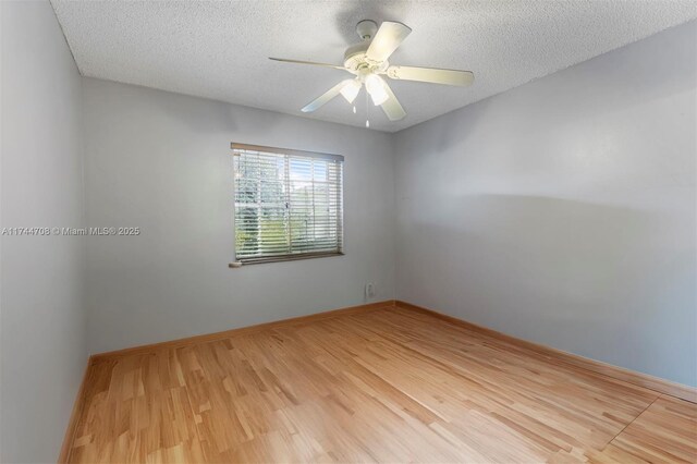 empty room with wood-type flooring, ceiling fan, and a textured ceiling