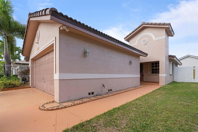 view of home's exterior with a garage and a lawn