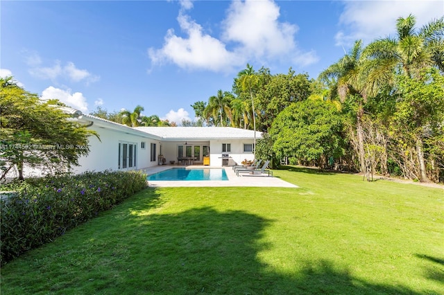 back of house with french doors, stucco siding, a patio, a lawn, and an outdoor pool