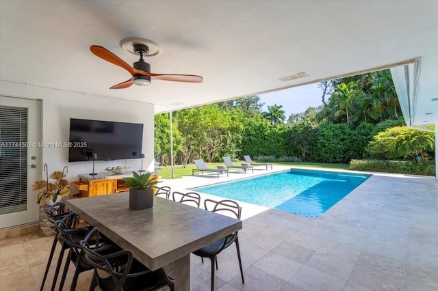 view of swimming pool featuring a bar, ceiling fan, and a patio area