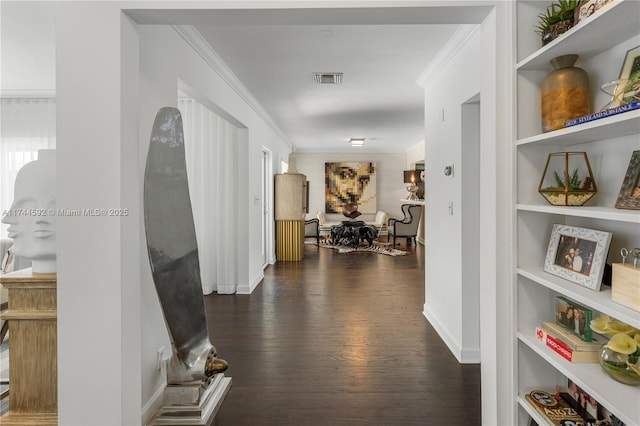hallway with visible vents, baseboards, ornamental molding, dark wood-type flooring, and built in features