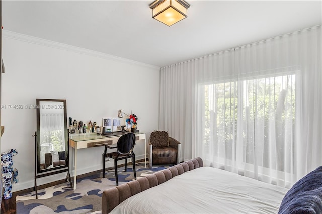 bedroom with baseboards, wood finished floors, and ornamental molding