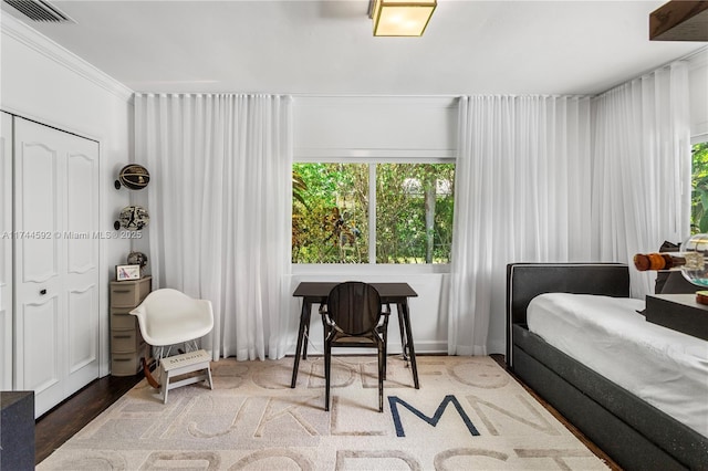 bedroom with hardwood / wood-style floors and ornamental molding