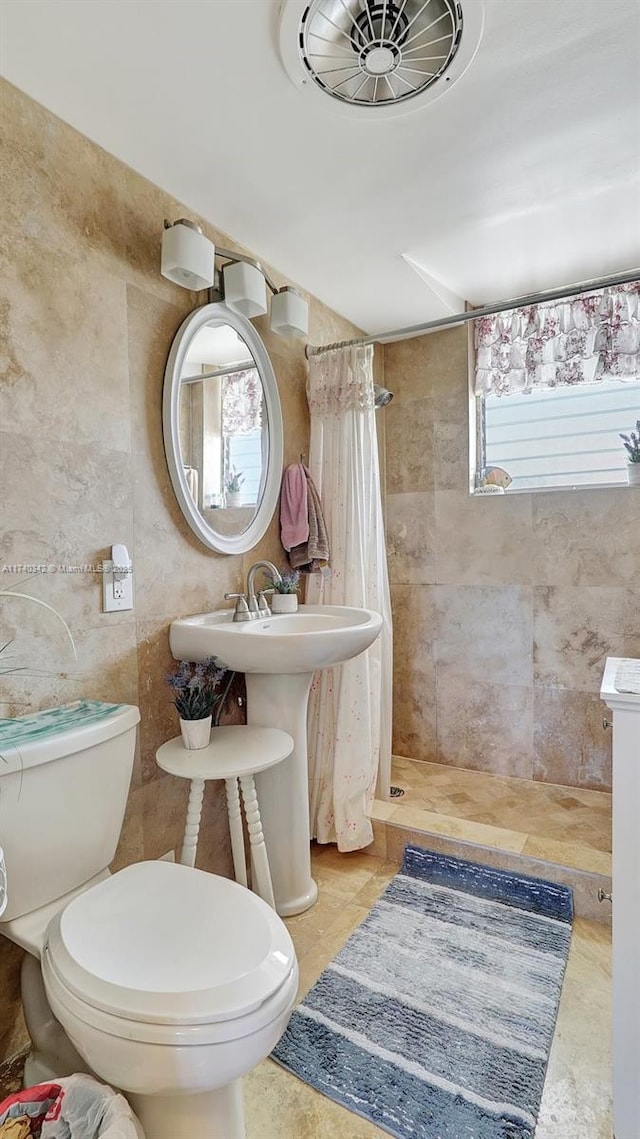 bathroom featuring toilet, sink, and a shower with shower curtain