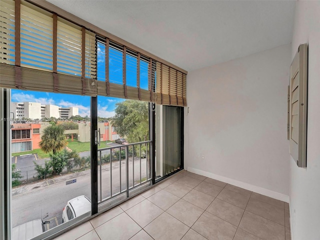 spare room with floor to ceiling windows and light tile patterned floors