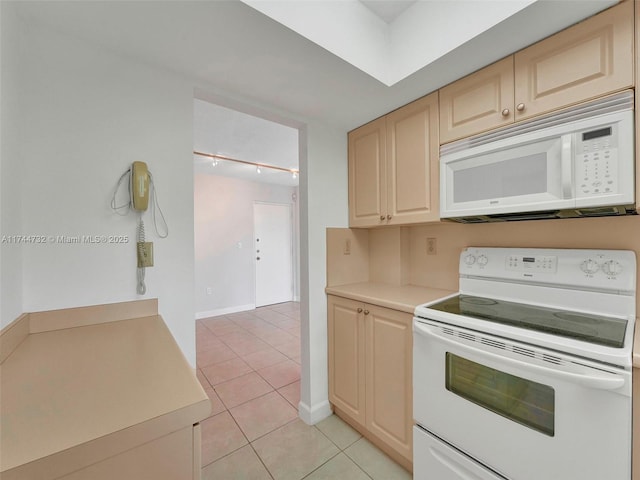 kitchen with light tile patterned floors, white appliances, and light brown cabinets