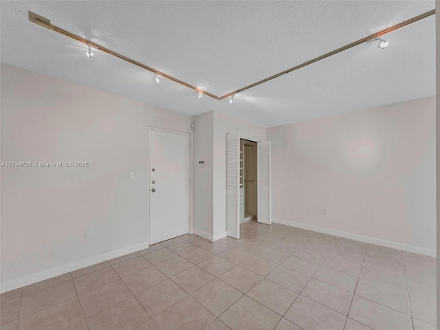 tiled spare room featuring a textured ceiling