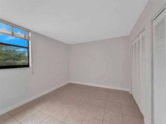 unfurnished bedroom with light tile patterned floors and a textured ceiling