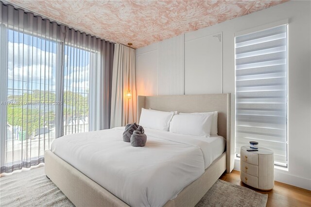 bedroom featuring wood-type flooring and access to outside