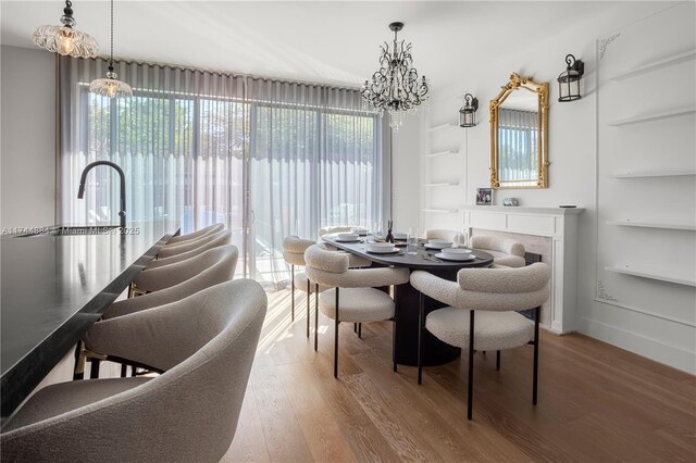 dining area featuring plenty of natural light, hardwood / wood-style floors, a chandelier, and built in shelves