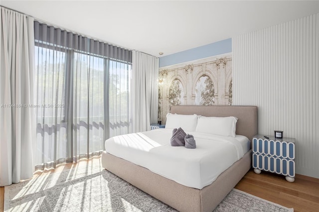 bedroom with radiator and hardwood / wood-style flooring