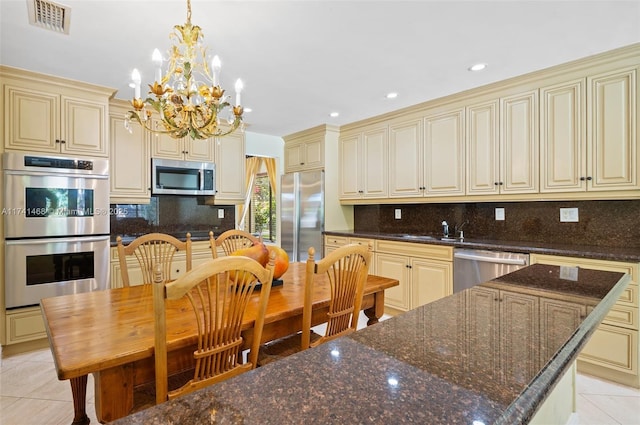 2061 NE 207th St, Miami, FL 33179 - kitchen featuring cream cabinetry, appliances with stainless steel finishes, light tile patterned flooring, and recessed lighting