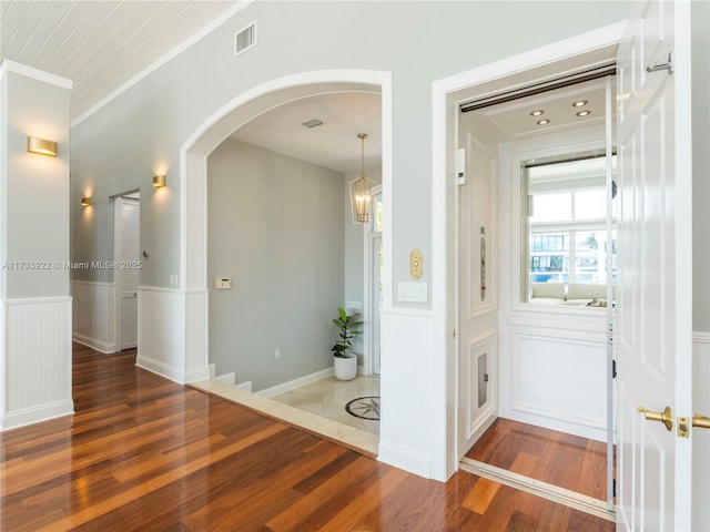 hall featuring ornamental molding and dark hardwood / wood-style flooring