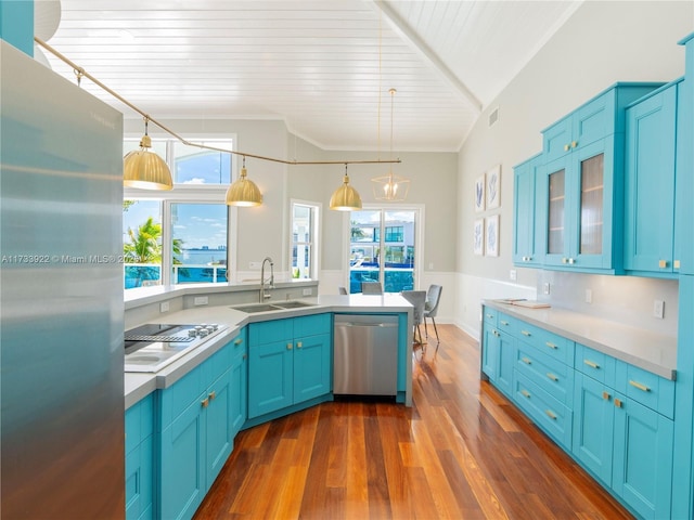 kitchen featuring blue cabinets, sink, hanging light fixtures, stainless steel appliances, and dark wood-type flooring