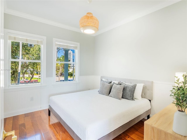 bedroom with hardwood / wood-style flooring and crown molding