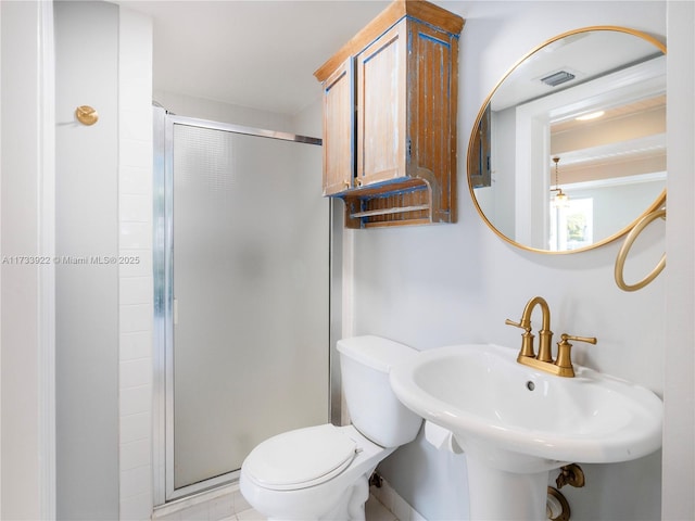 bathroom with a shower with door, sink, and toilet