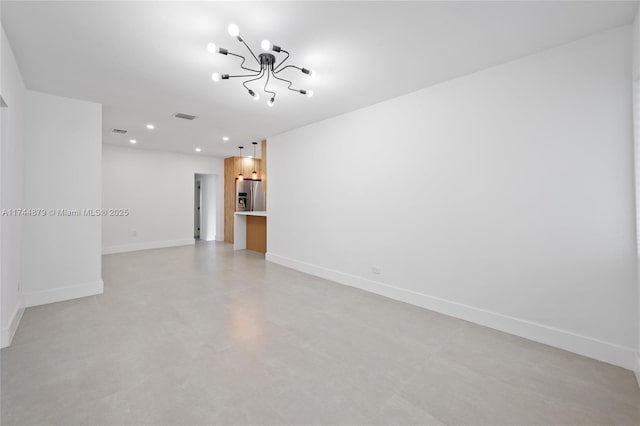 empty room featuring concrete flooring, a notable chandelier, recessed lighting, visible vents, and baseboards