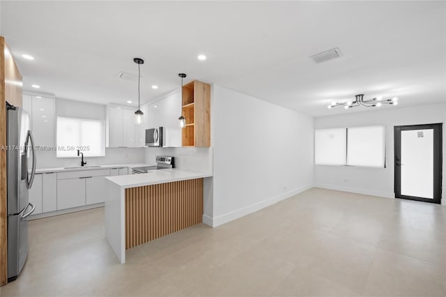 kitchen with open floor plan, a peninsula, stainless steel appliances, open shelves, and a sink