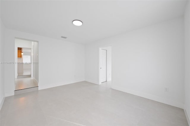 empty room with visible vents and baseboards