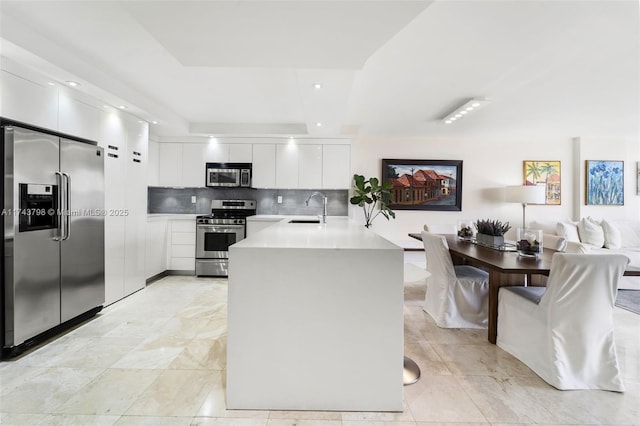 kitchen with white cabinetry, appliances with stainless steel finishes, sink, and backsplash