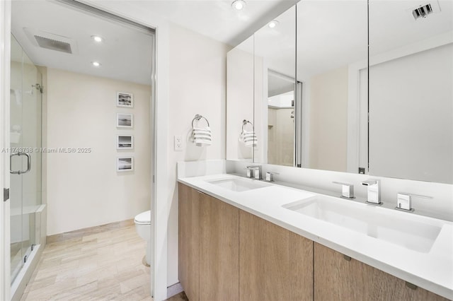 bathroom with vanity, an enclosed shower, and toilet