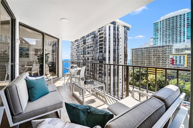 balcony featuring a water view and outdoor lounge area