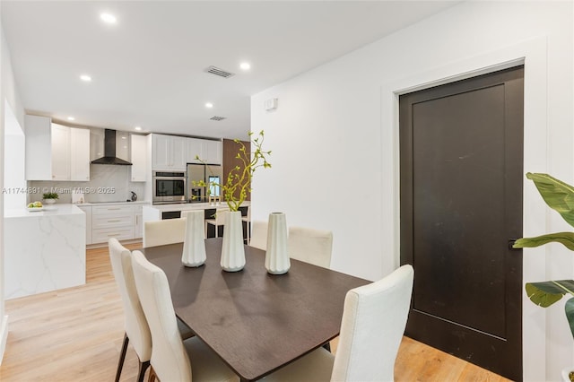 living room featuring sink and light hardwood / wood-style flooring