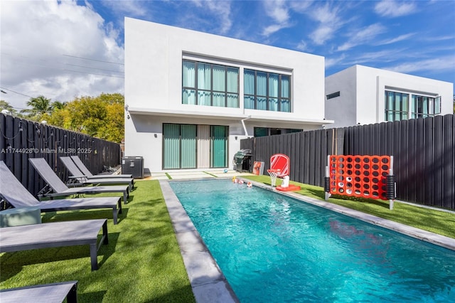 back of house with a patio, a fenced in pool, and a lawn