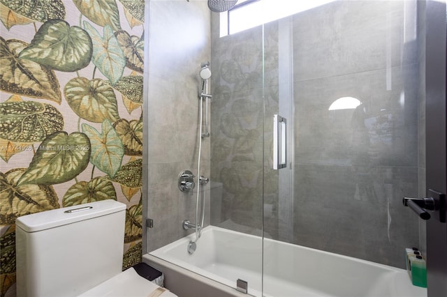 bathroom featuring toilet and tiled shower / bath