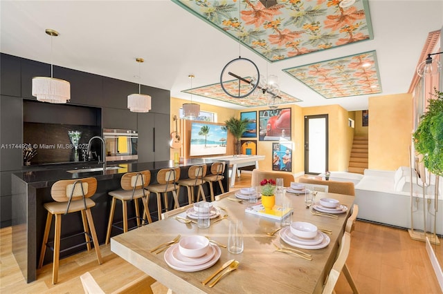 dining room featuring sink and light hardwood / wood-style floors