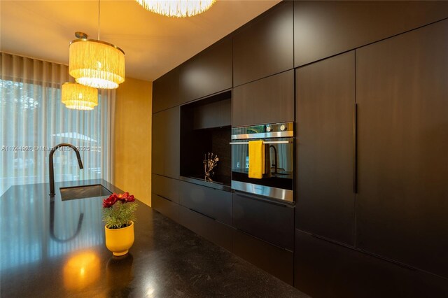 kitchen with hanging light fixtures, sink, oven, and an inviting chandelier