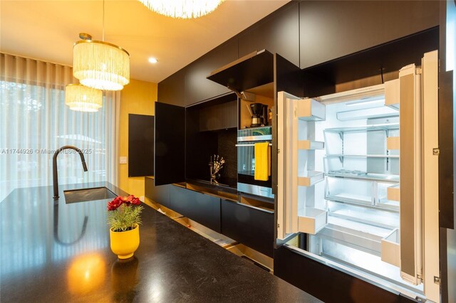 kitchen featuring sink, oven, an inviting chandelier, and decorative light fixtures