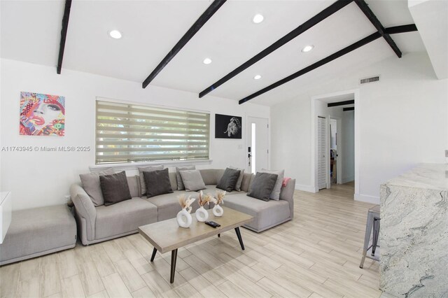 living room with light wood-type flooring and vaulted ceiling with beams