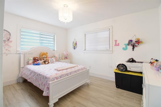 bedroom with a notable chandelier and light hardwood / wood-style floors