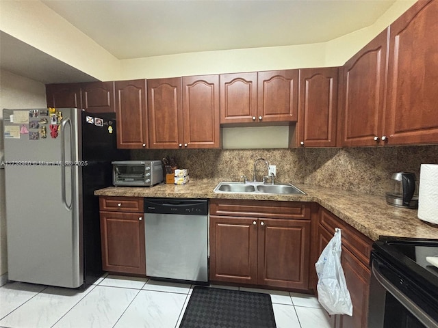 kitchen featuring a toaster, decorative backsplash, light stone counters, stainless steel appliances, and a sink