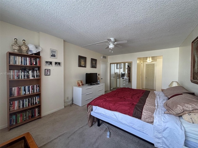 carpeted bedroom with a textured ceiling, ceiling fan, and a closet