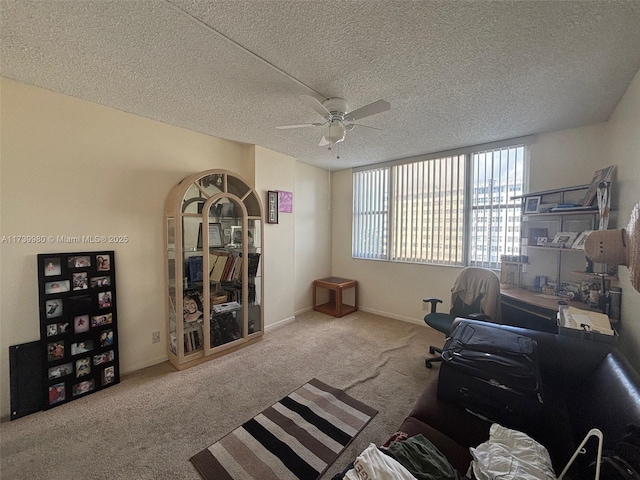 office space with light carpet, ceiling fan, and a textured ceiling